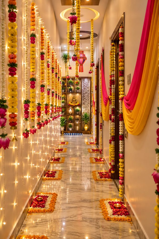 Diwali decor: corridor with marigold and rose garland curtains, fairy lights and petal rangoli