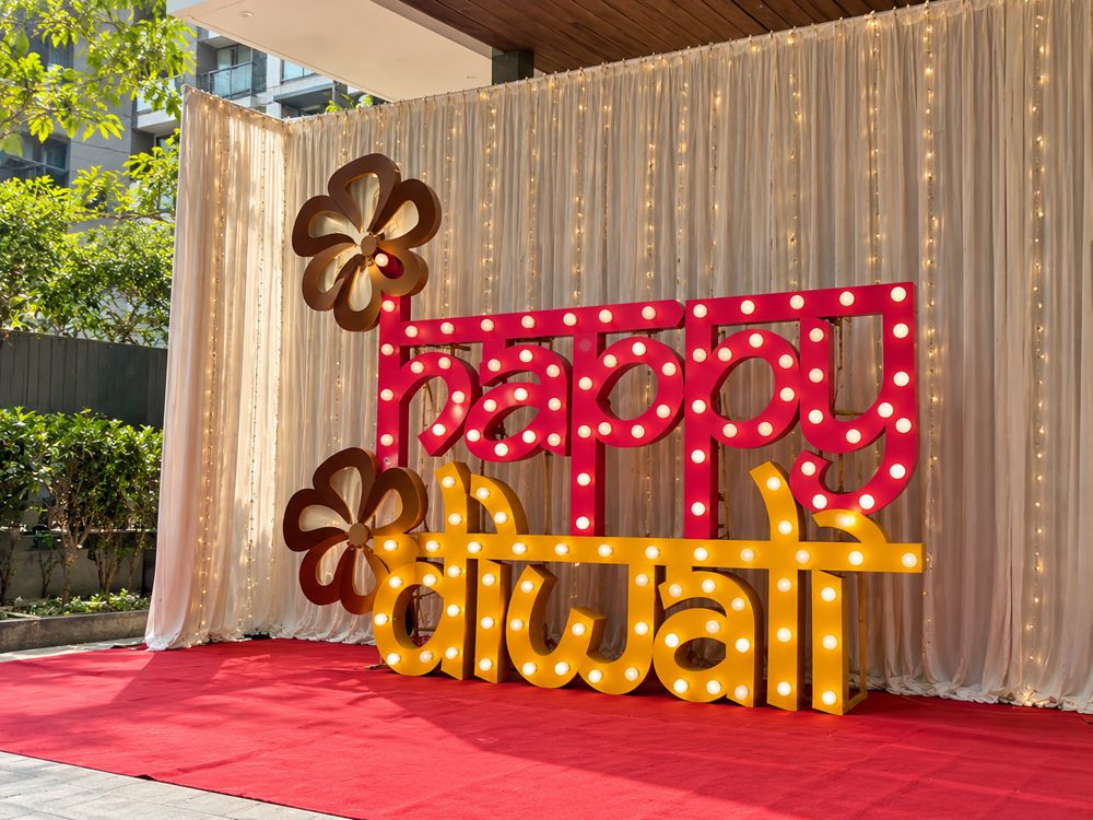 Diwali decor: Happy Diwali marquee letters with cream drapes and a red carpet