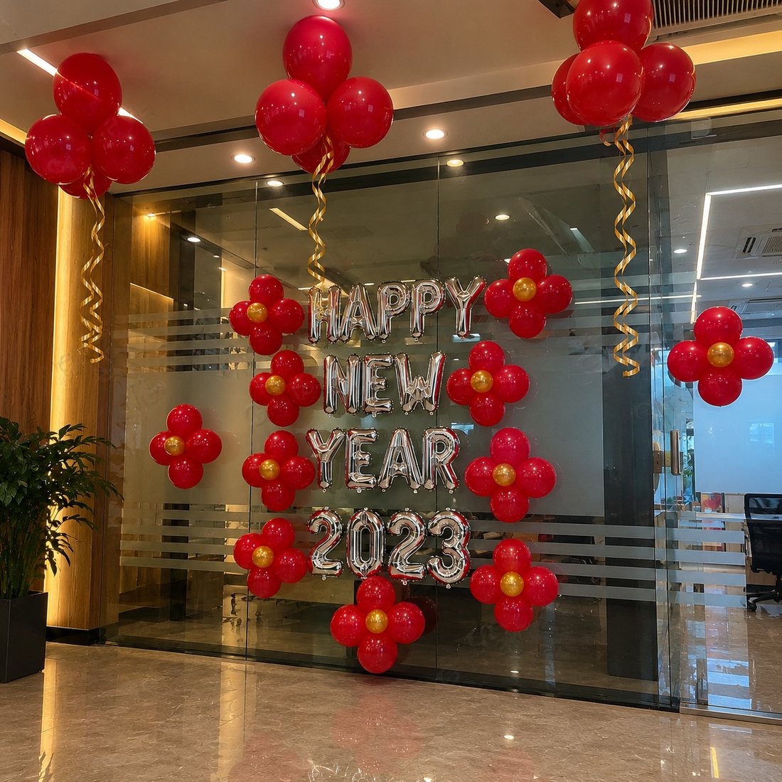 New Year decor: red balloon clusters and silver Happy New Year foil letters on an office glass wall